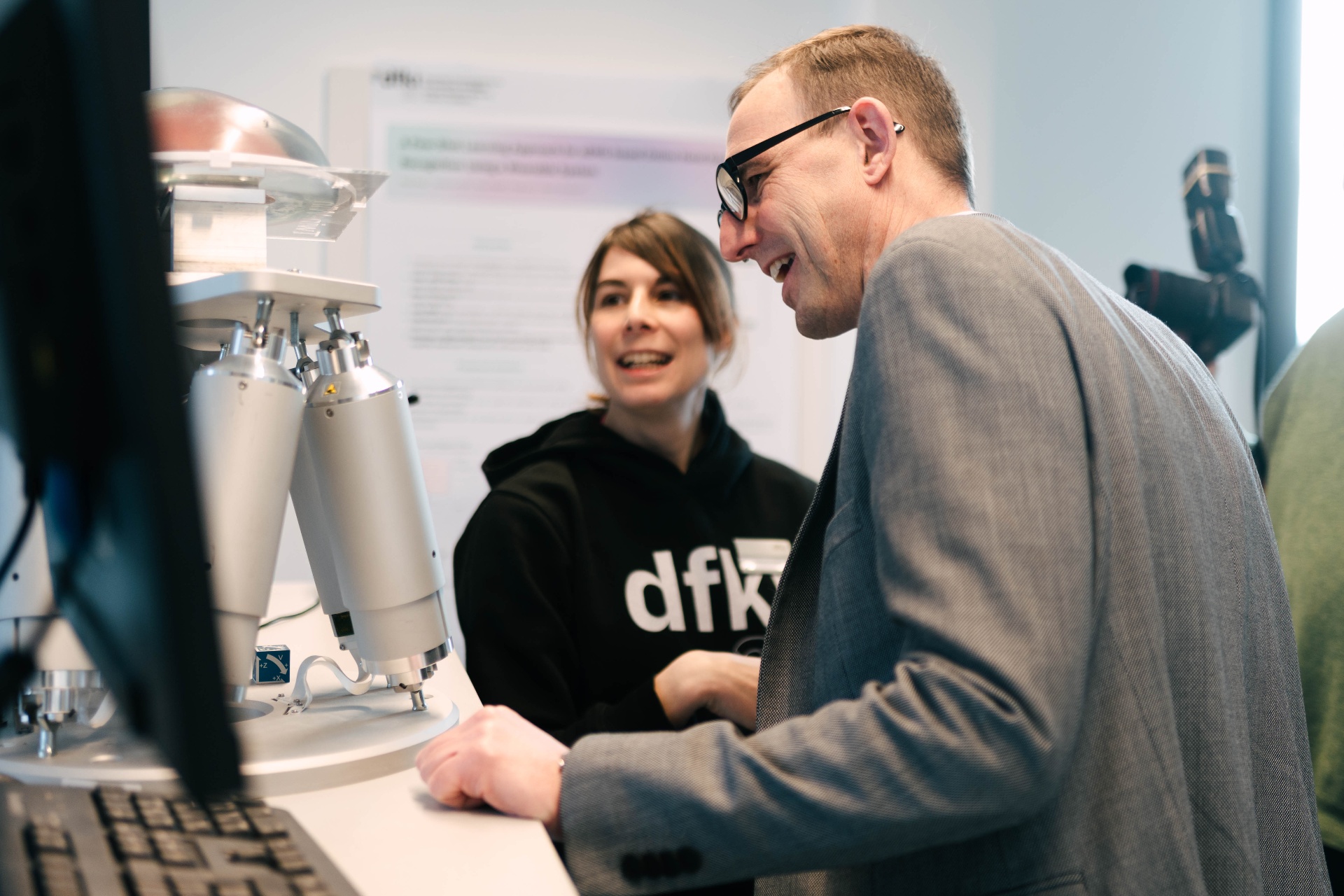 Executive engaging with a DFKI researcher at a robotics demonstration